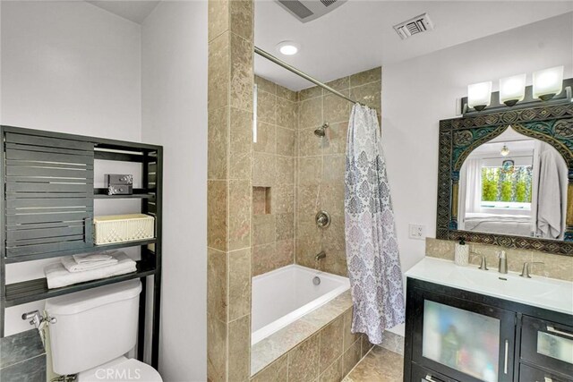 full bathroom with tiled shower / bath combo, visible vents, toilet, and vanity