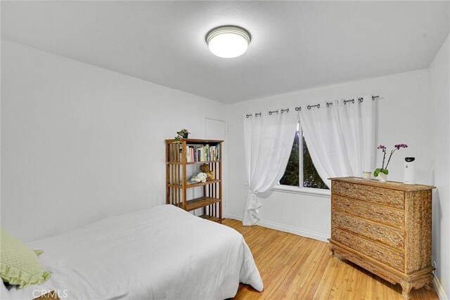 bedroom with baseboards and light wood-style floors