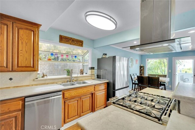 kitchen featuring light countertops, brown cabinetry, appliances with stainless steel finishes, and a sink