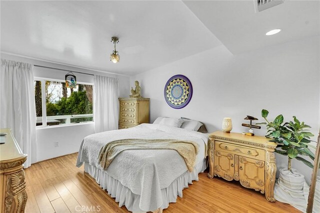 bedroom with visible vents and light wood-style flooring