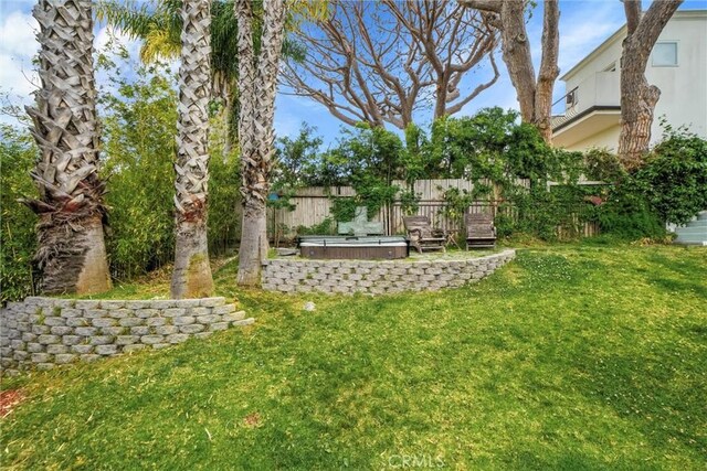 view of yard featuring a hot tub, a patio, and fence