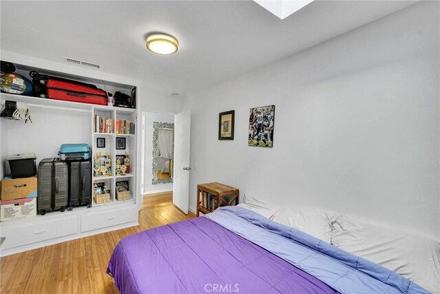 bedroom featuring wood finished floors and visible vents