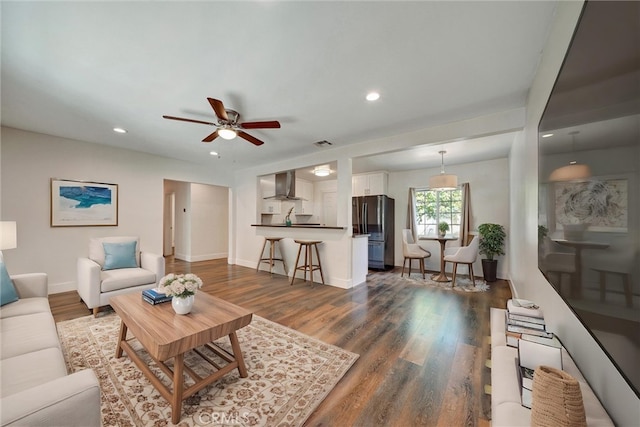 living area featuring a ceiling fan, recessed lighting, baseboards, and dark wood finished floors