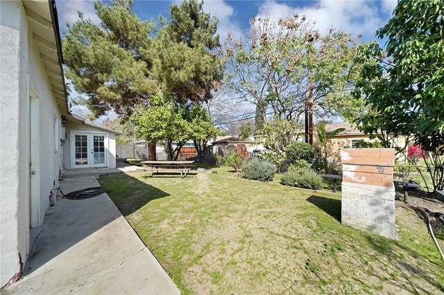 view of yard with a fenced backyard, french doors, and a patio area