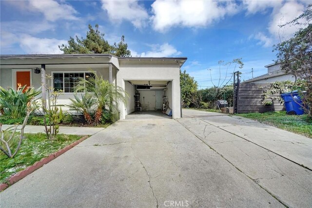 view of side of property with driveway, stucco siding, and a garage