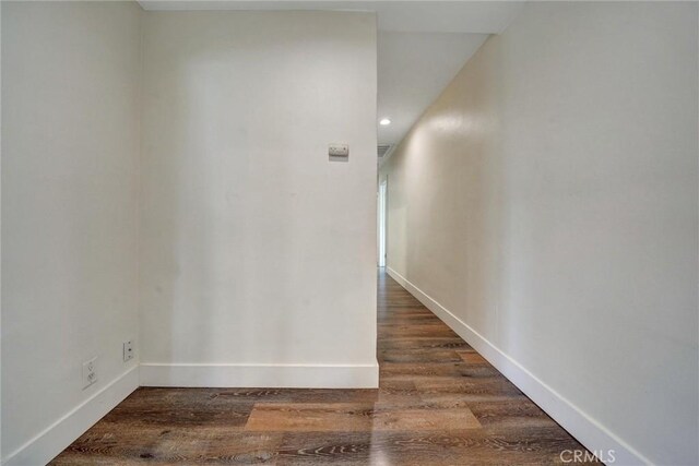 hallway with baseboards and wood finished floors