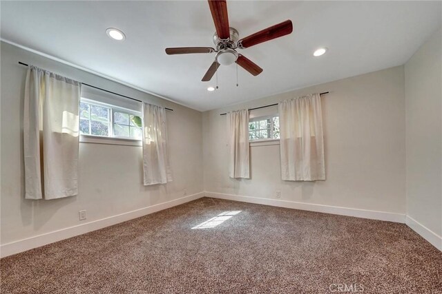 spare room with baseboards, a wealth of natural light, and carpet