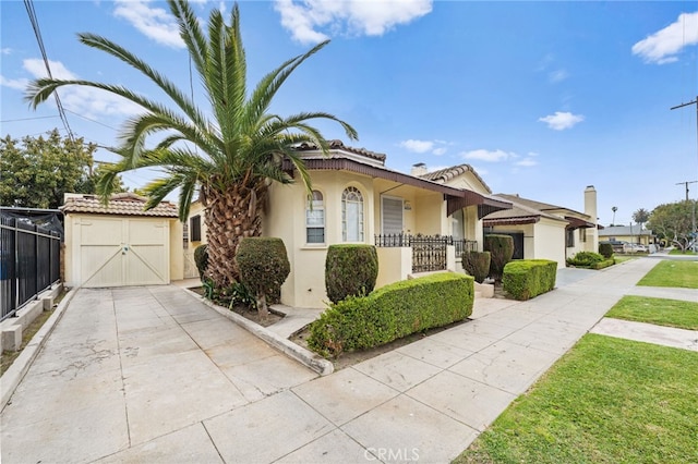 view of front of property with stucco siding, fence, a garage, and concrete driveway