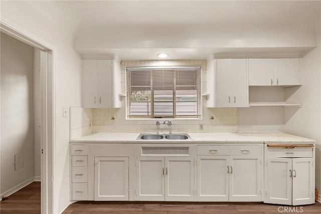 kitchen with dark wood-style floors, white cabinets, a sink, and backsplash