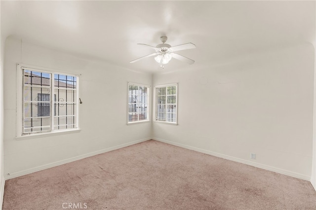 spare room featuring carpet flooring, a ceiling fan, and baseboards