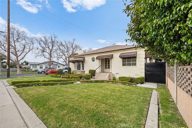 bungalow-style home featuring a chimney, stucco siding, fence, and a front lawn