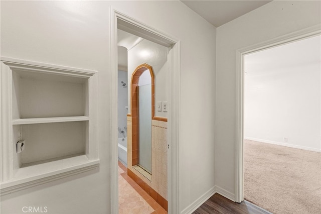 hallway with carpet flooring and baseboards