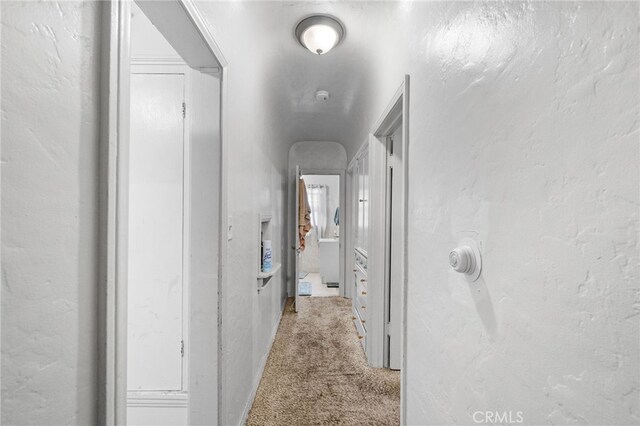 hall with light colored carpet