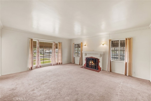 unfurnished living room featuring carpet floors, crown molding, and a tile fireplace