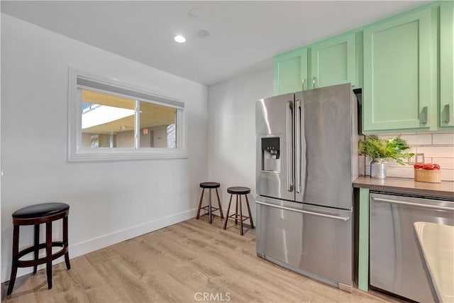 1 3rd Pl Unit 302, Long Beach, CA 90802 - kitchen with stainless steel appliances, green cabinetry, light wood finished floors, baseboards, and backsplash