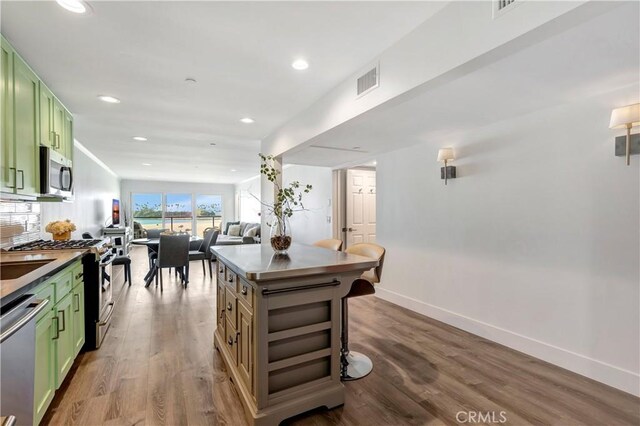 1 3rd Pl Unit 302, Long Beach, CA 90802 - kitchen featuring green cabinets, appliances with stainless steel finishes, wood finished floors, recessed lighting, and baseboards