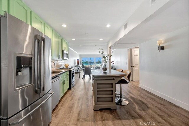 1 3rd Pl Unit 302, Long Beach, CA 90802 - kitchen featuring green cabinets, stainless steel appliances, a sink, light wood-style floors, and recessed lighting