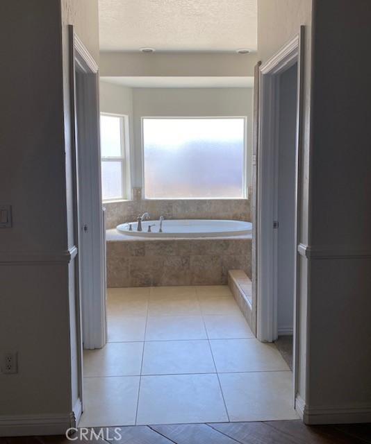 23073 Cielito Dr, Apple Valley, CA 92308 - full bathroom featuring a garden tub, a textured ceiling, and tile patterned flooring
