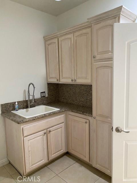 23073 Cielito Dr, Apple Valley, CA 92308 - kitchen featuring light brown cabinets, light tile patterned flooring, and dark stone countertops