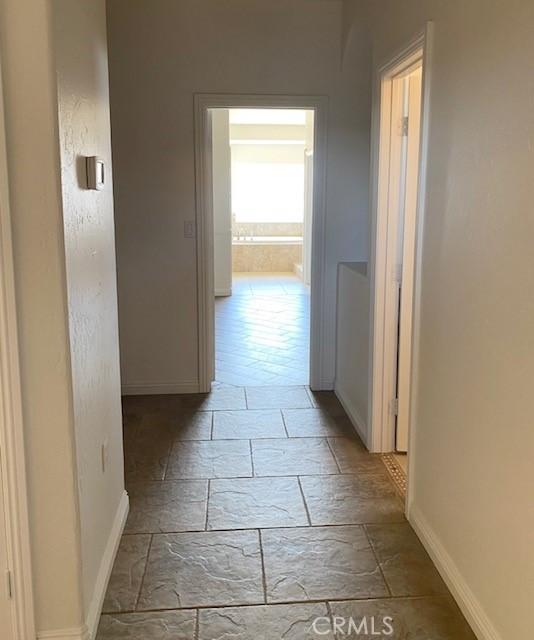 23073 Cielito Dr, Apple Valley, CA 92308 - hallway featuring baseboards and stone tile flooring