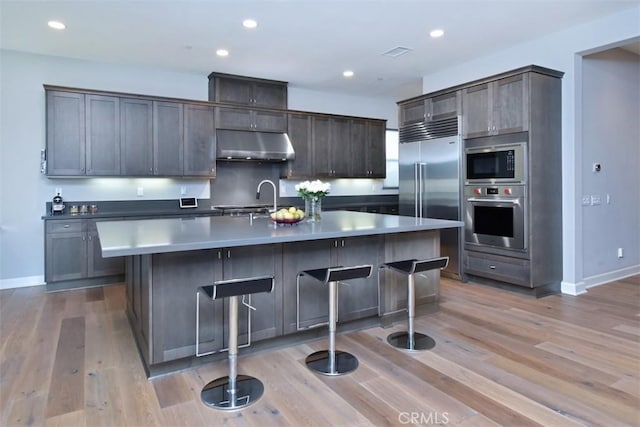 14608 Mccormick St, Sherman Oaks, CA 91411 - kitchen featuring built in appliances, under cabinet range hood, baseboards, light wood-type flooring, and recessed lighting
