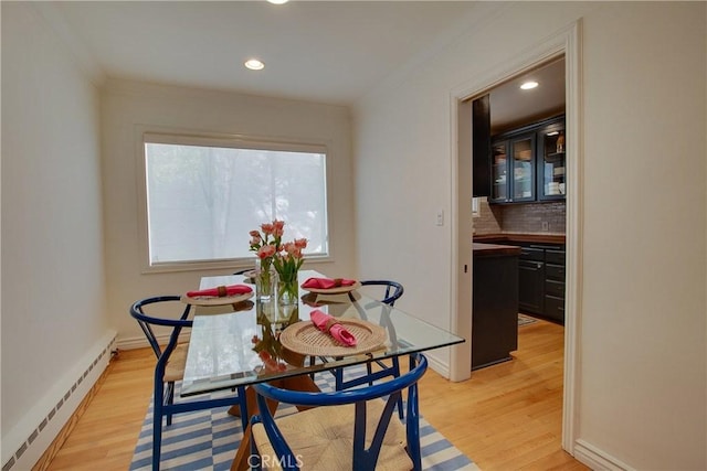 dining area featuring a baseboard heating unit, crown molding, recessed lighting, and light wood-style flooring