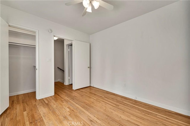 unfurnished bedroom featuring light wood finished floors, a closet, ceiling fan, and baseboards