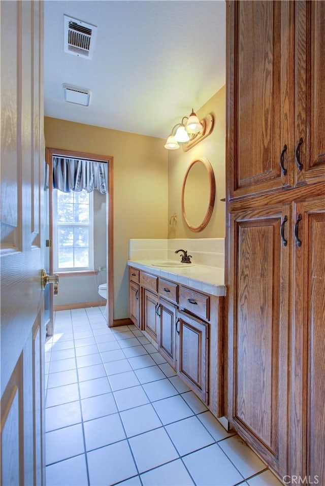 bathroom featuring tile patterned floors, vanity, toilet, and visible vents