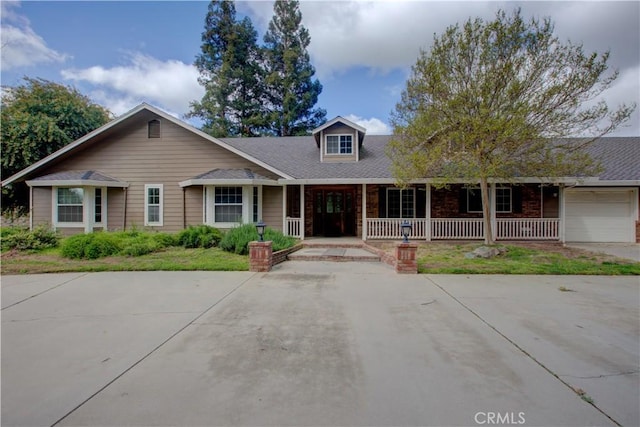 view of front of house with a porch, concrete driveway, and an attached garage