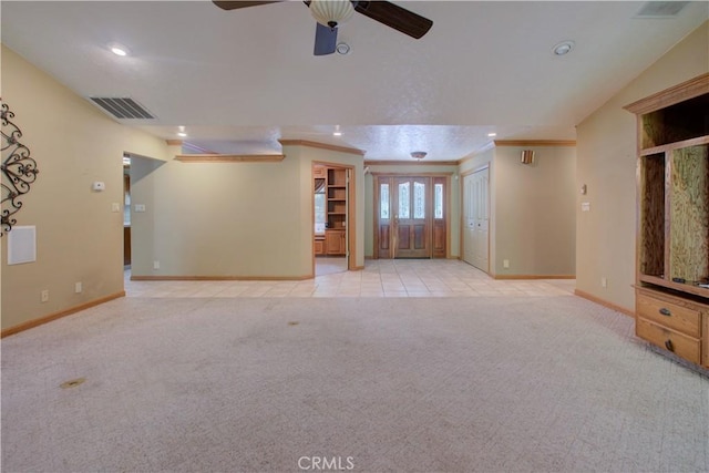 unfurnished living room with crown molding, carpet flooring, a ceiling fan, baseboards, and visible vents