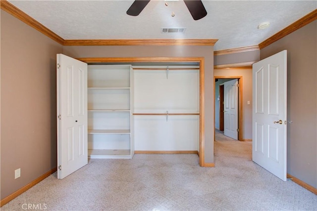 unfurnished bedroom with crown molding, carpet, a textured ceiling, visible vents, and a closet