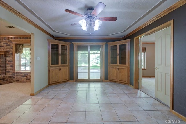 spare room featuring light tile patterned floors, brick wall, a healthy amount of sunlight, and ceiling fan