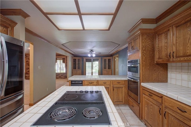 kitchen with tile countertops, refrigerator, double oven, and brown cabinets
