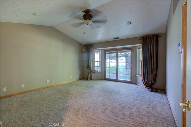 unfurnished room with a ceiling fan, a textured ceiling, lofted ceiling, baseboards, and visible vents