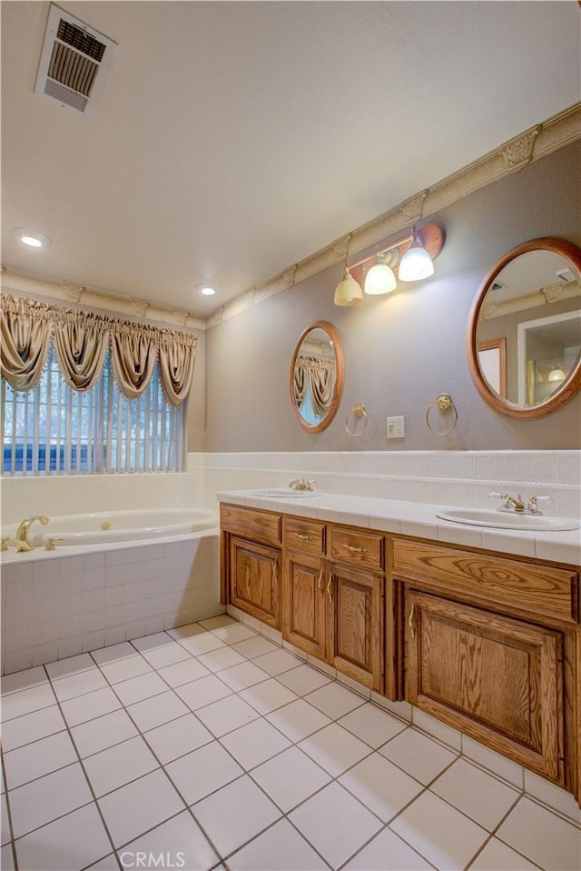 bathroom with visible vents, double vanity, a sink, a garden tub, and tile patterned flooring