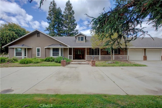 view of front of property with an attached garage, covered porch, and concrete driveway
