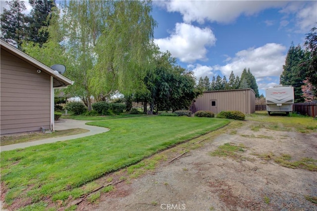 view of yard with fence and an outdoor structure