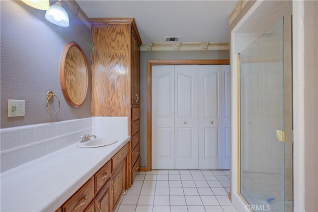 full bathroom featuring visible vents, tiled shower, tile patterned flooring, and vanity