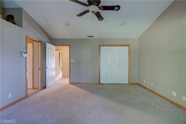 unfurnished bedroom featuring baseboards, lofted ceiling, visible vents, and carpet