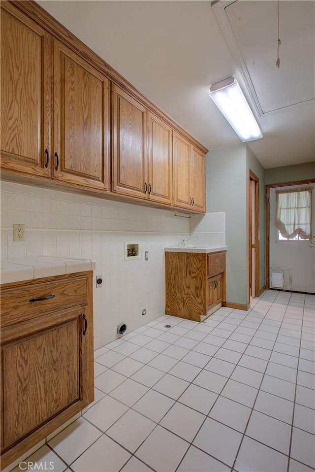laundry area featuring hookup for a washing machine, attic access, electric dryer hookup, cabinet space, and light tile patterned floors