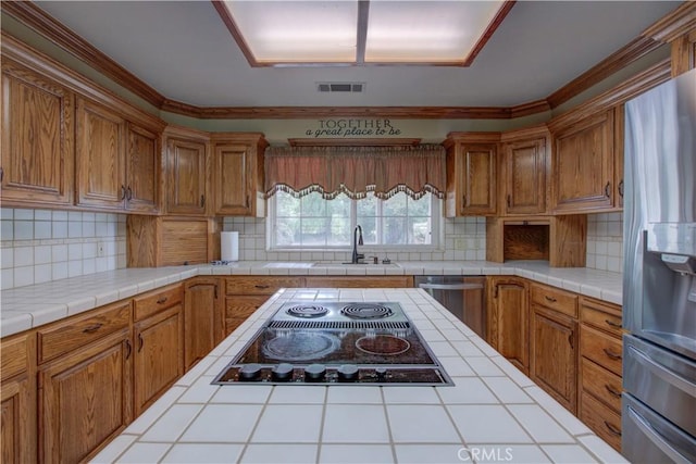 kitchen featuring visible vents, a sink, brown cabinetry, and appliances with stainless steel finishes