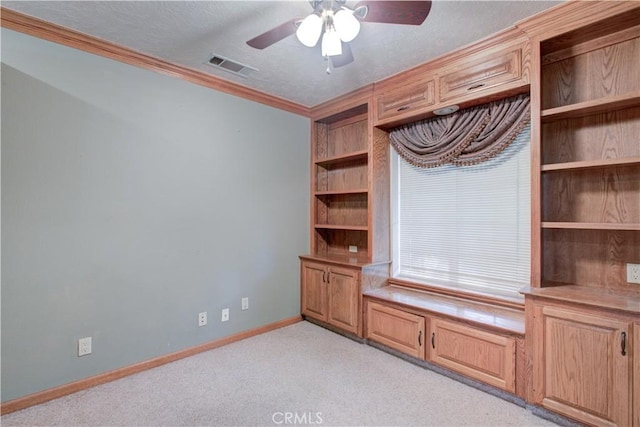 unfurnished office with a textured ceiling, visible vents, baseboards, ceiling fan, and light colored carpet