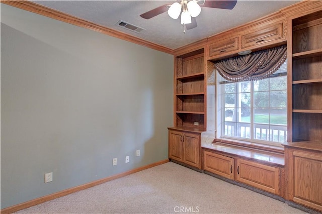 unfurnished office with light carpet, visible vents, ceiling fan, and a textured ceiling