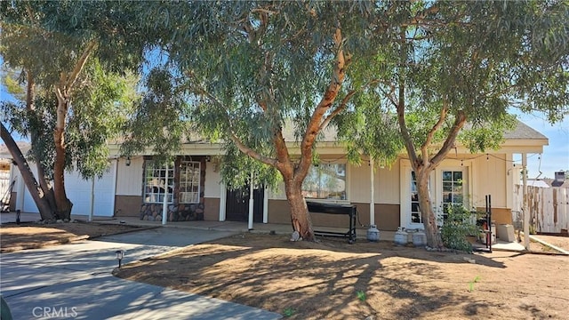 view of front of home featuring fence and concrete driveway