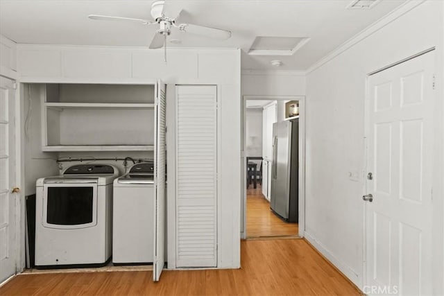 laundry room featuring laundry area, crown molding, light wood finished floors, attic access, and washing machine and clothes dryer