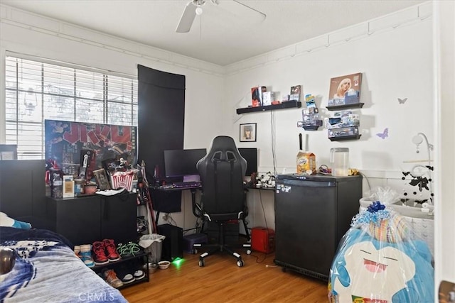 bedroom with ceiling fan, fridge, and wood finished floors