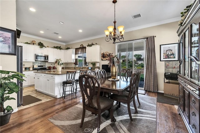 455 Everest Peak, Beaumont, CA 92223 - dining area featuring a chandelier, ornamental molding, visible vents, and light wood-style flooring