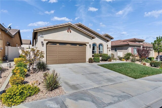 455 Everest Peak, Beaumont, CA 92223 - mediterranean / spanish house featuring a tiled roof, a garage, fence, concrete driveway, and stucco siding
