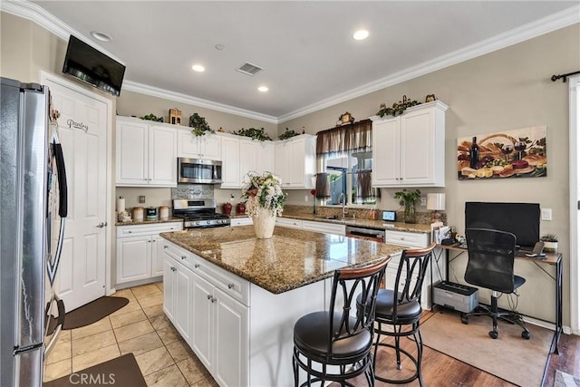 455 Everest Peak, Beaumont, CA 92223 - kitchen featuring crown molding, appliances with stainless steel finishes, a center island, and visible vents