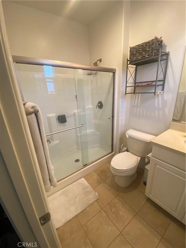full bathroom with a shower stall, toilet, vanity, and tile patterned flooring